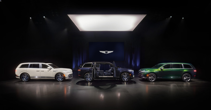 Three Genesis GV90 models on the reveal stage under the Genesis wing emblem
