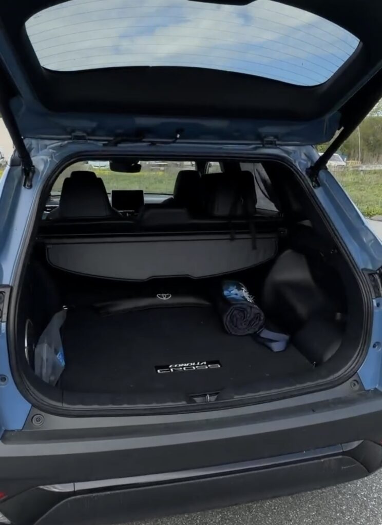 Cargo area of the 2026 Toyota Corolla Cross Hybrid with the tonneau cover and folded blanket