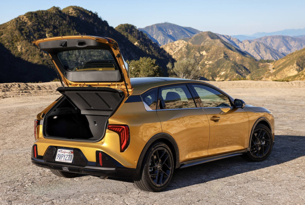 2026 Kia K4 hatchback rear three-quarter view in gold with the hatch open