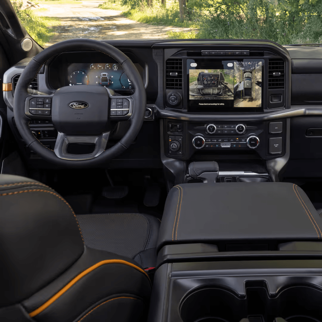 2025 Ford F-150 Tremor interior showing the digital cluster, center touchscreen with 360 camera, and fold-flat console work surface