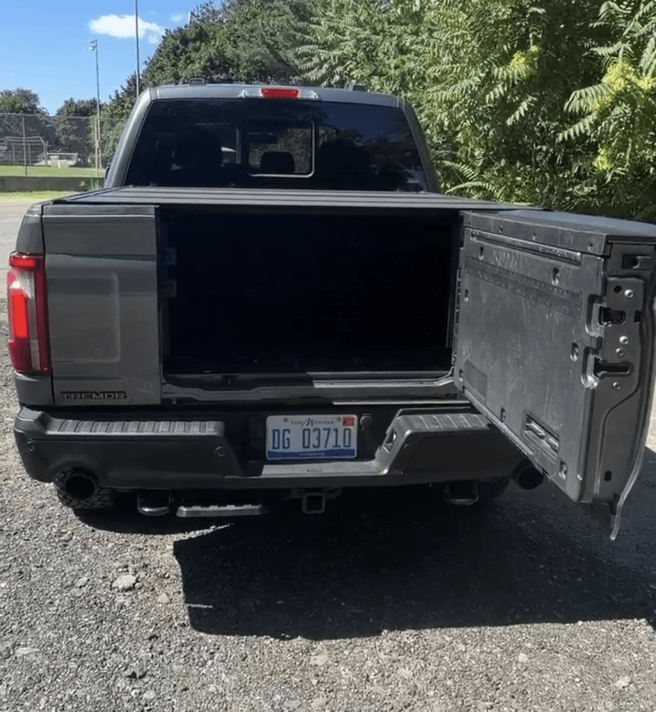 Multifunction tailgate split door open on the 2025 Ford F-150 Tremor showing the bed and kick-out bumper step area