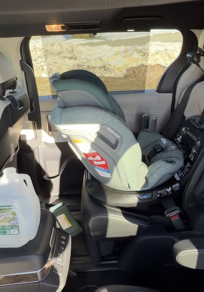 Maxi-Cosi car seat installed on the second-row captain\u0027s chair of the 2025 Toyota Sienna with a gallon of milk staged for the fridge