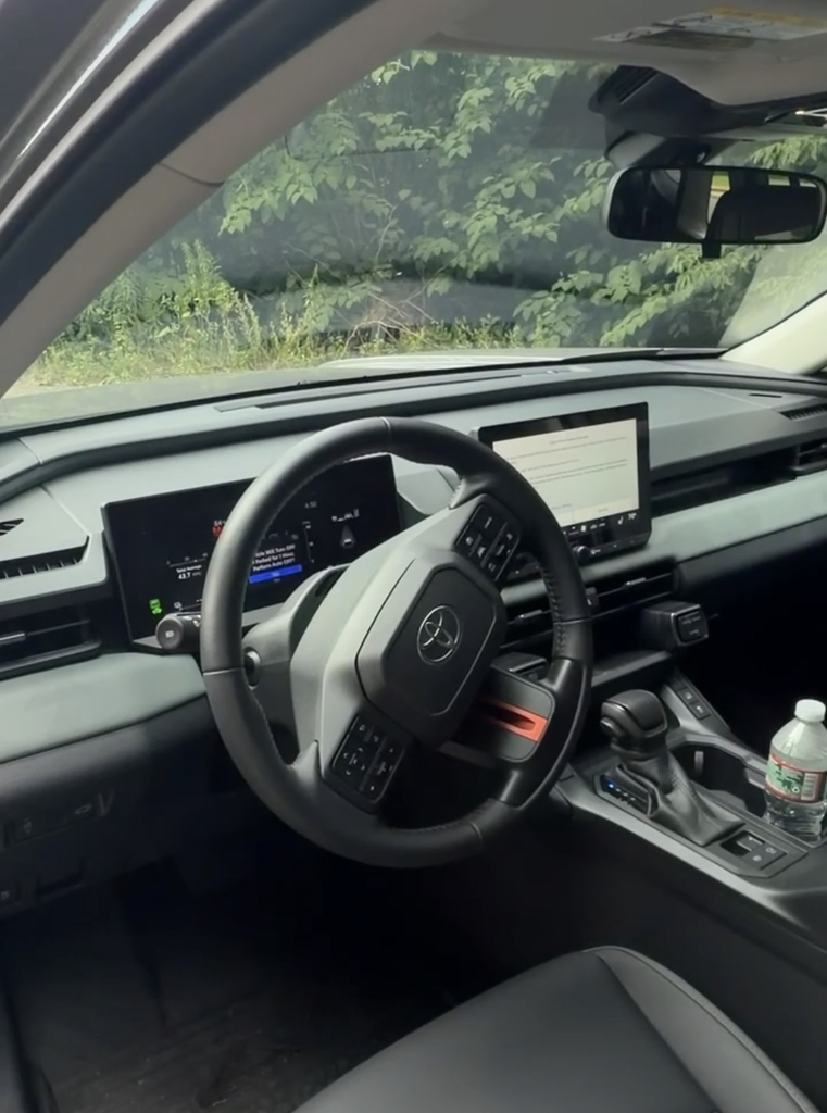 2026 Toyota RAV4 Woodland interior showing the squared steering wheel, digital cluster, and center touchscreen