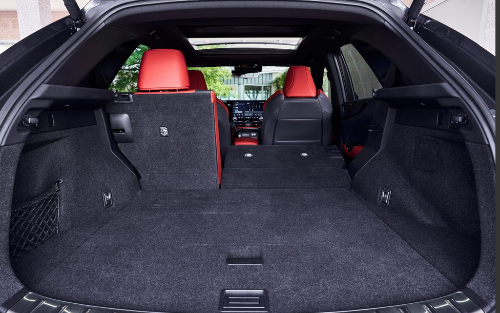 Cargo area of the Lexus NX with one rear seat folded, showing the red leather seats and panoramic roof