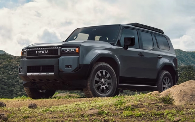 Dark gray Toyota Land Cruiser parked on a grassy hilltop