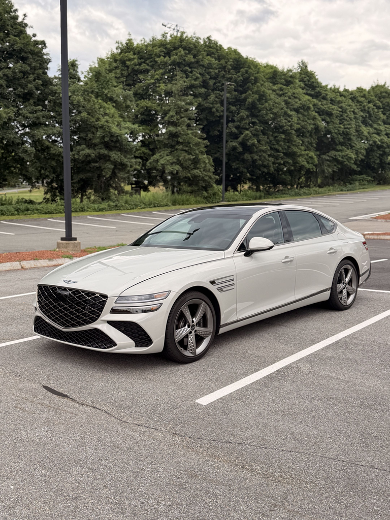 White 2025 Genesis G80 3.5T Sport Prestige front three quarter in a parking lot