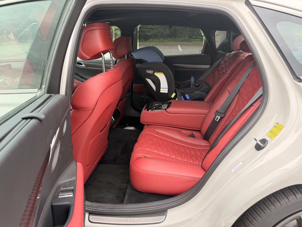 2025 Genesis G80 red Nappa rear seat with a child car seat installed