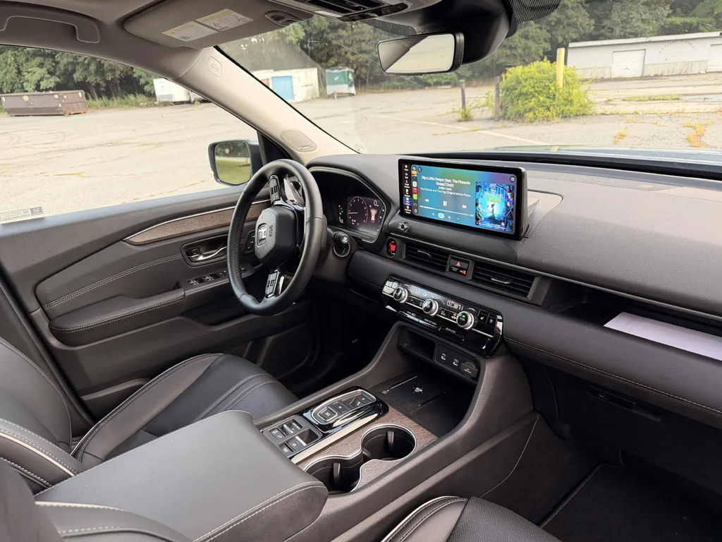 2026 Honda Pilot Elite interior showing the 12.3-inch touchscreen, physical climate controls, and push-button gear selector