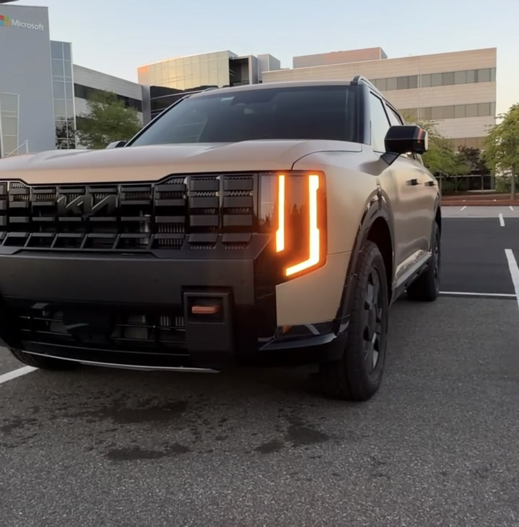 2027 Kia Telluride X-Pro front view in matte Terrain showing the blacked-out grille and amber lighting signature