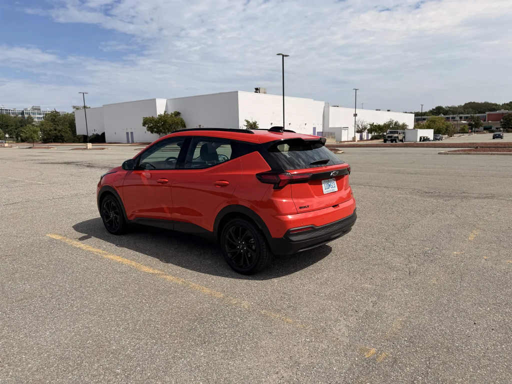 2027 Chevrolet Bolt RS rear three-quarter view in red showing the hatchback profile