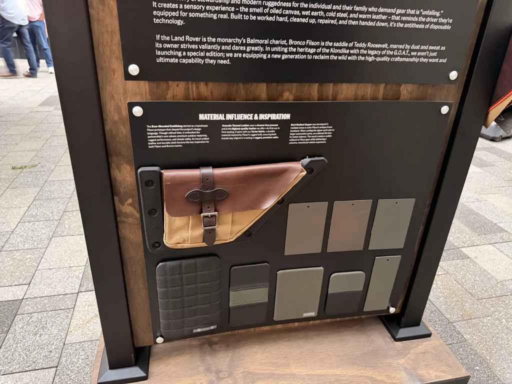 Material influence display at the Bronco Filson reveal showing the original Filson side bag prototype and fabric samples