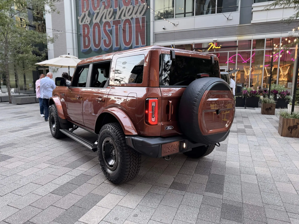 Rear three-quarter view of the Bronco Filson First Edition in Iron Sands Copper Metallic in front of the Boston is the new Boston mural