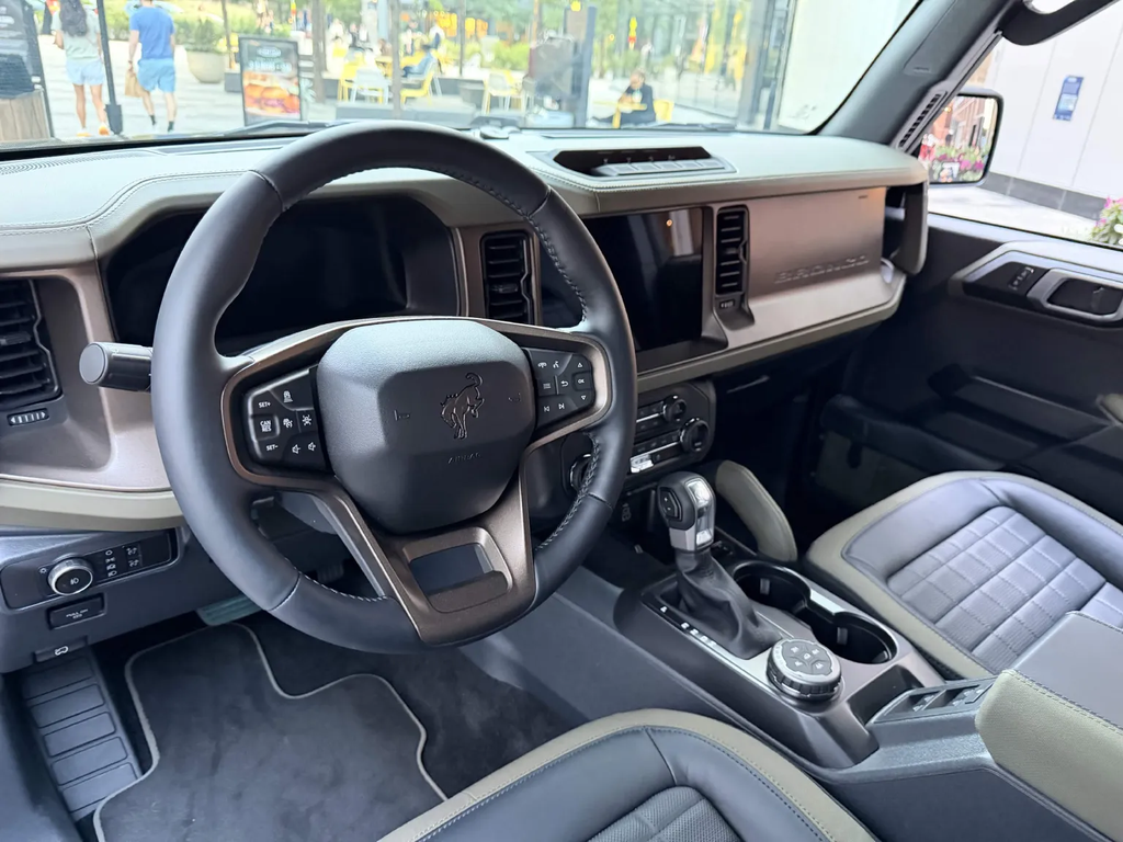 Ford Bronco Filson interior showing the leather-wrapped dash, bronze accents, and quilted leather seats