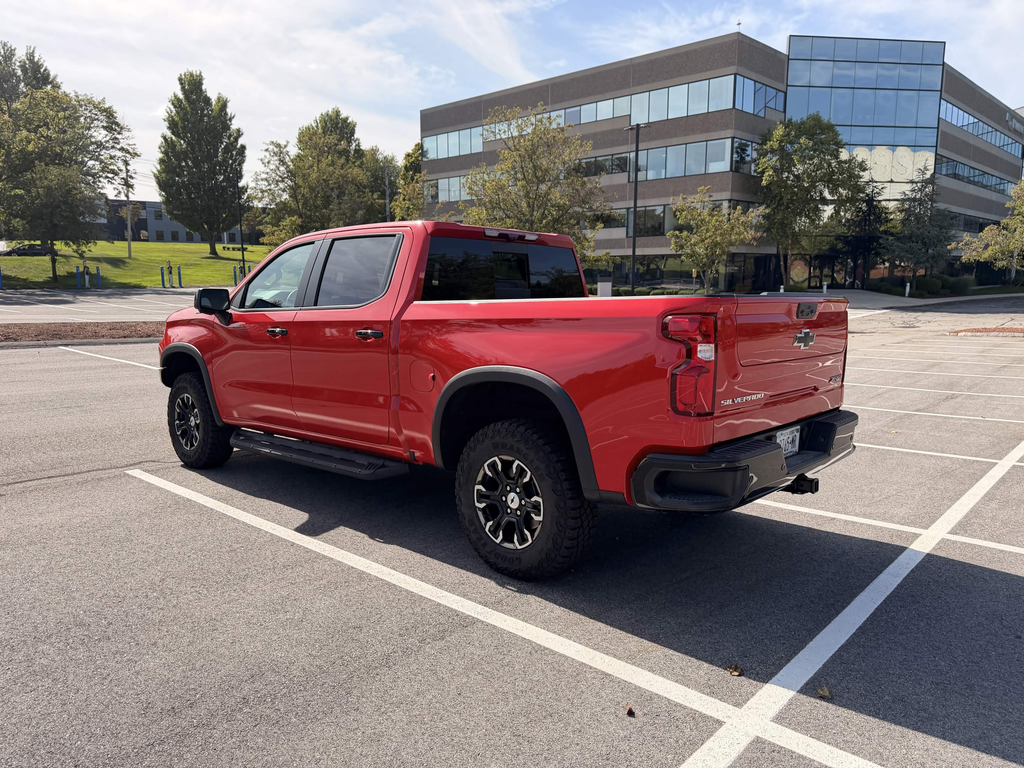 2026 Chevrolet Silverado ZR2 rear three-quarter view in Red Hot showing the lifted stance and 33-inch tires