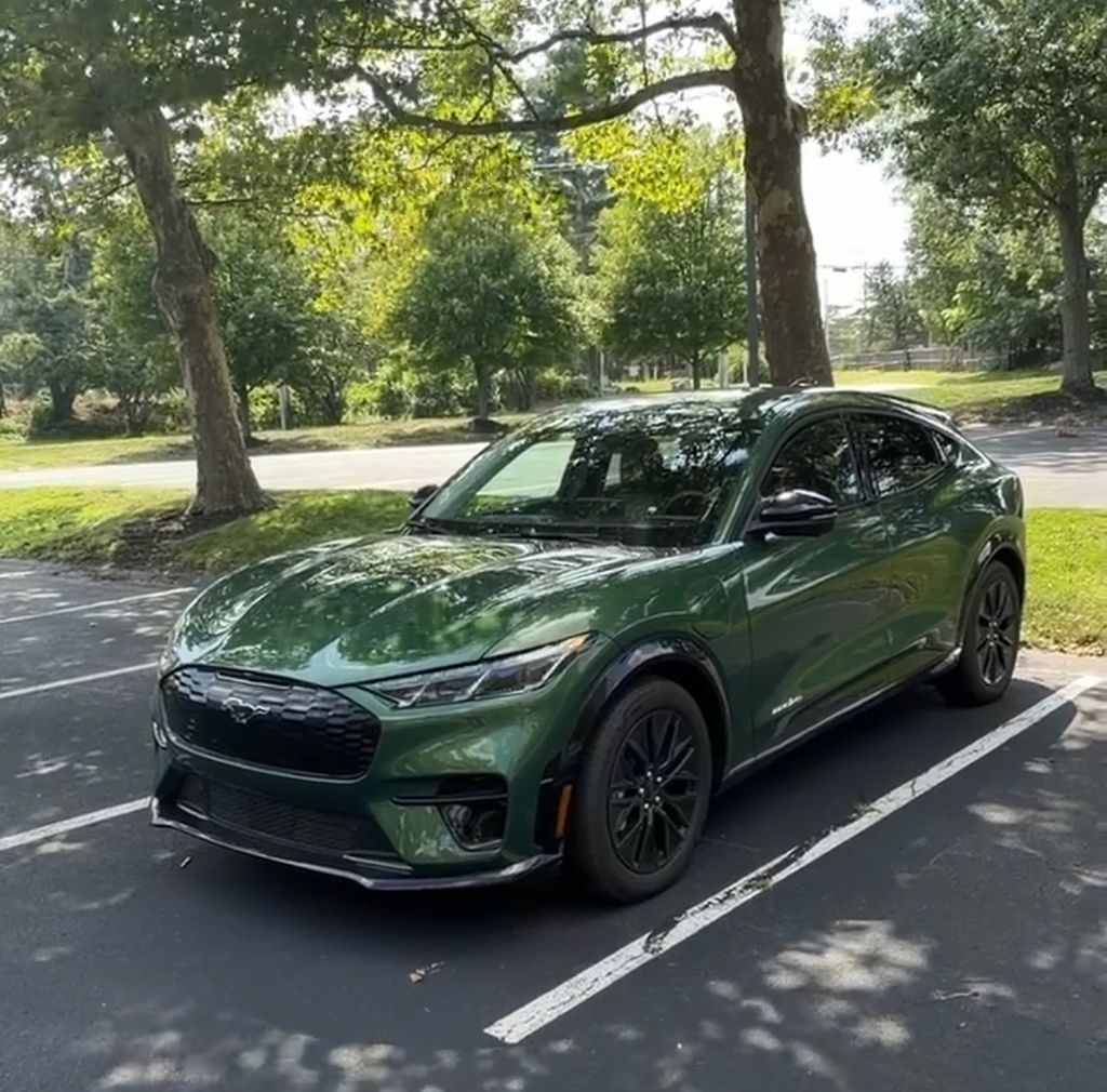 2026 Ford Mustang Mach-E front three-quarter view in Eruption Green showing the 2026 facelift fascia and black wheels