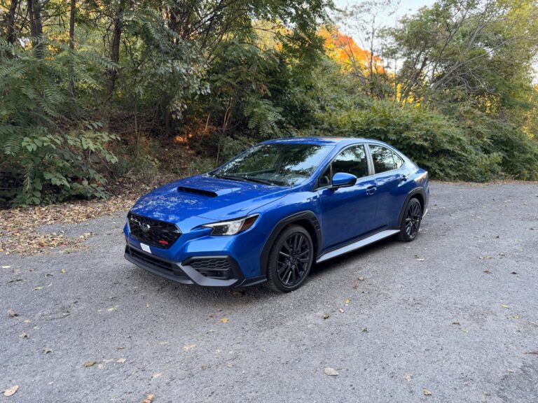 2026 Subaru WRX base in WR Blue Pearl, front three quarter view parked on a gravel road in fall foliage
